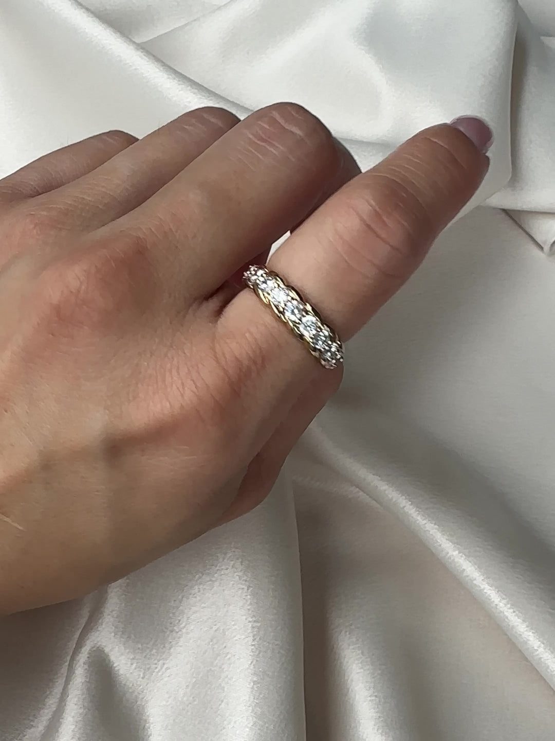 Gold ring with clear gemstones on a white background
