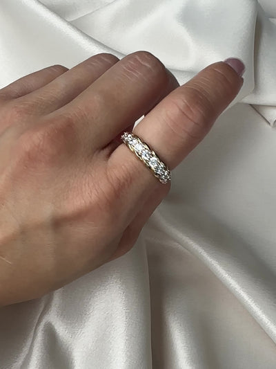 Gold ring with clear gemstones on a white background
